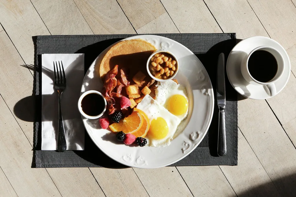 Un plato de comida en una mesa con una taza de café.